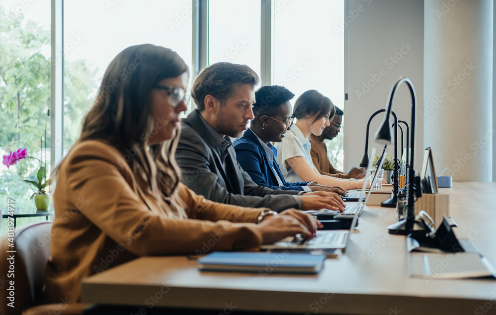 People Sitting At Desks Looking At Computers